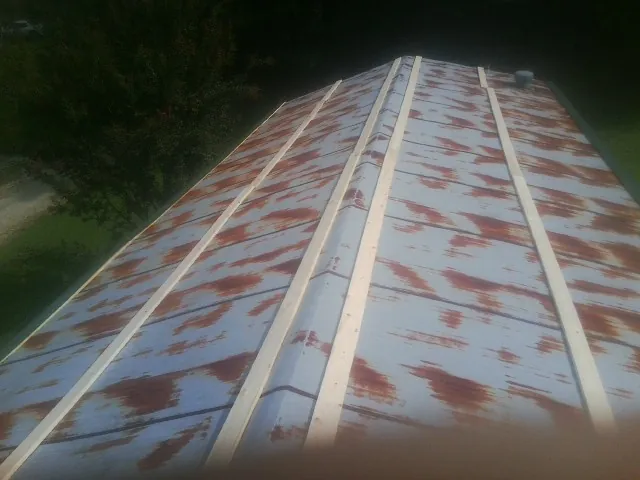 Rusted metal roof panels with new wood purlins before replacement — Storm Damage Roof Repair in Topsfield by Roofing Brothers