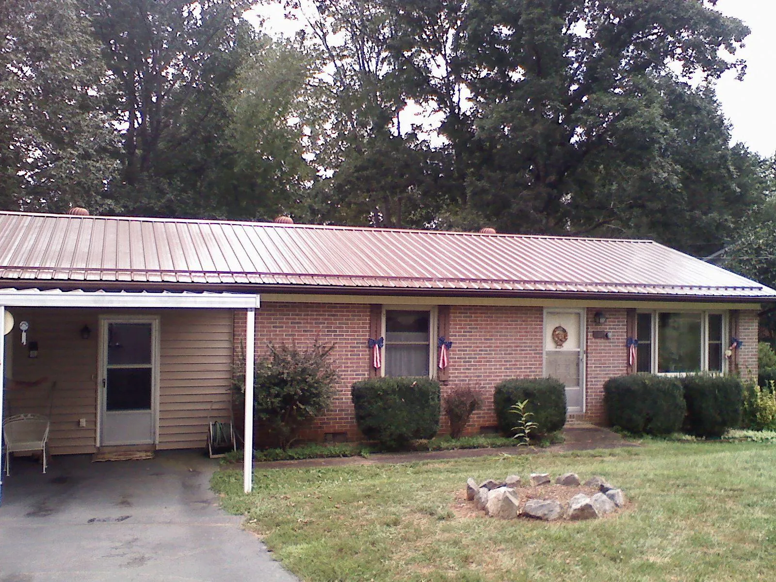 Bronze metal roof and carport on a brick ranch home — Roof Repair work by our crew in Topsfield
